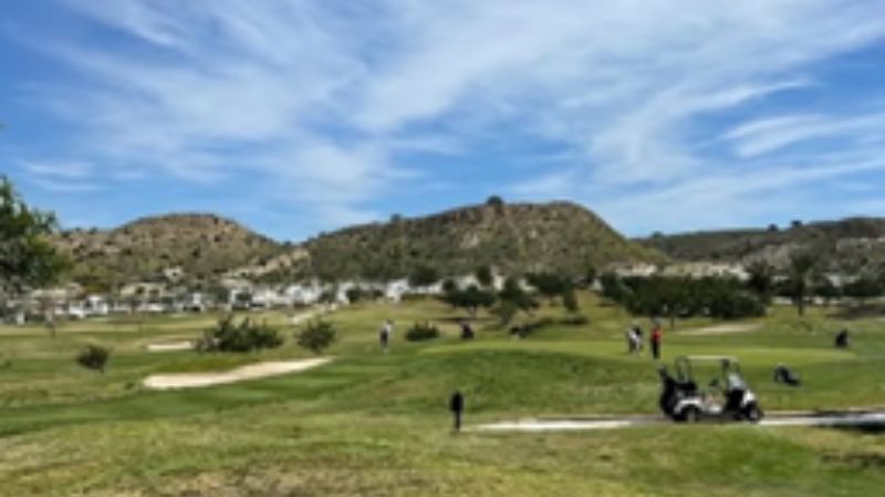 Golfbana med berg i bakgrunden .